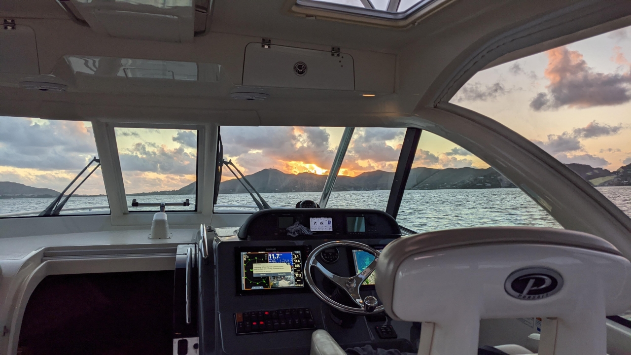 A view of mountains through the tempered windshield on a Pursuit Offshore boat