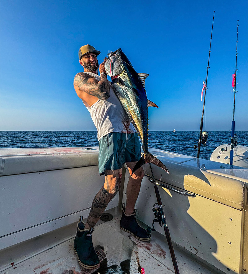A fisherman proudly displays his freshly caught bluefin tuna aboard his Pursuit OS 385 Offshore.